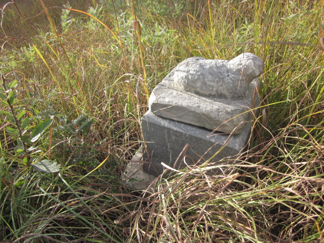 small cement gravestone with lamb
