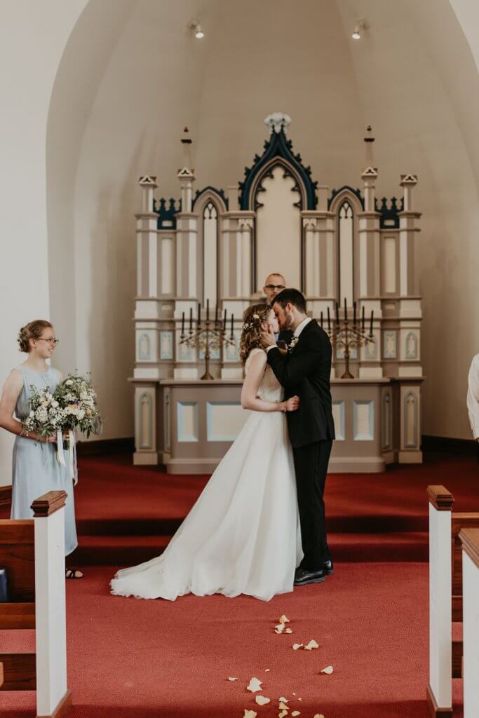 bride & groom kissing in chapel
