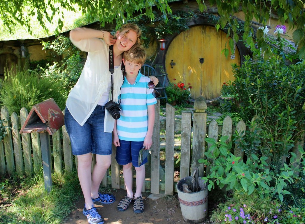 girl and boy in front of hobbit home with round yellow door