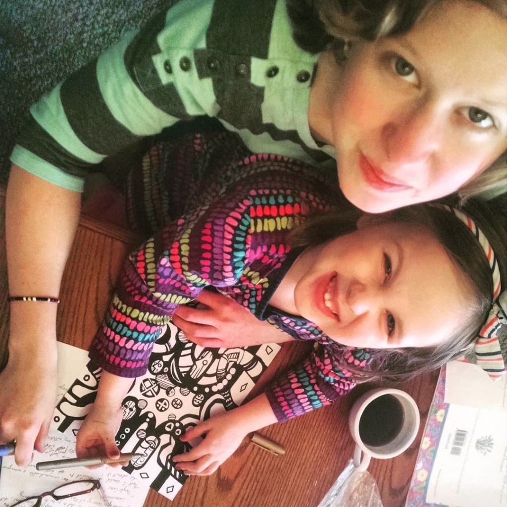 young lady and child coloring together