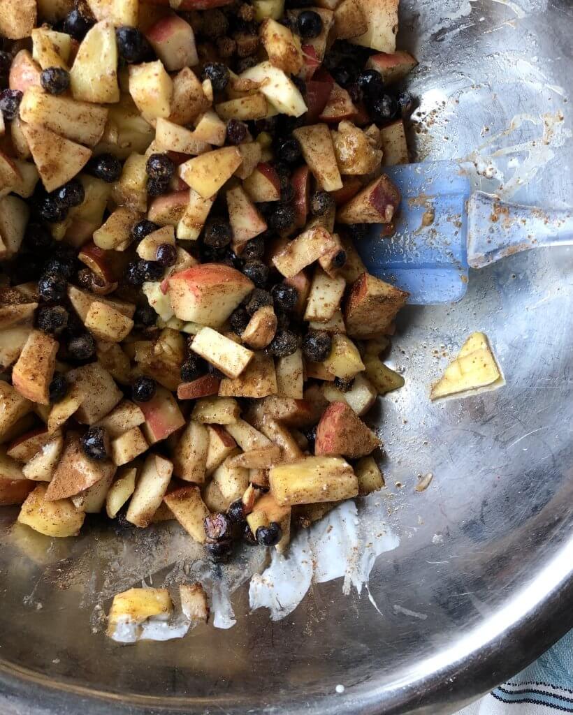 bowl full of chopped fruits stirred into aronia berry chutney