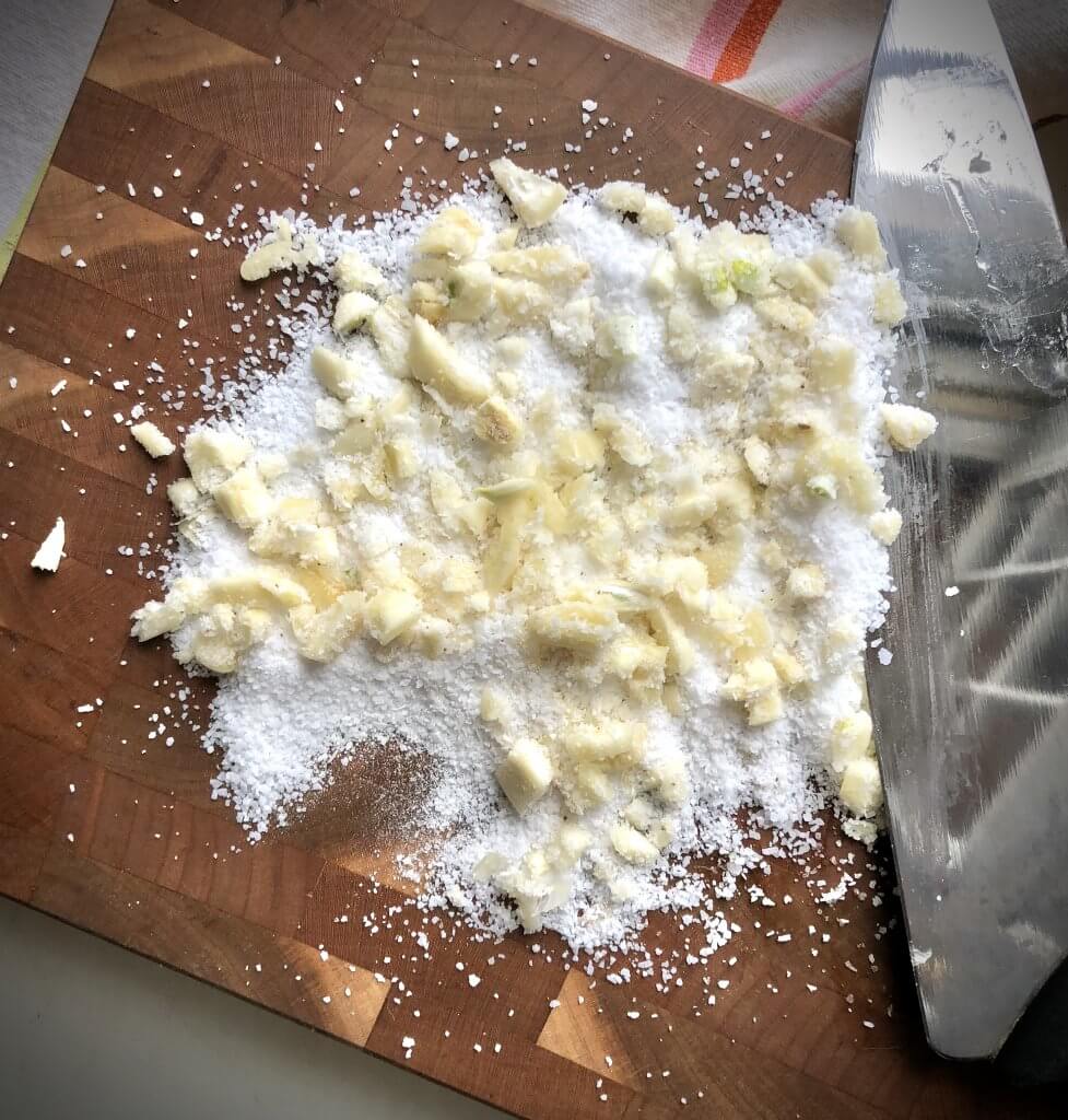 board with salt and crushed garlic