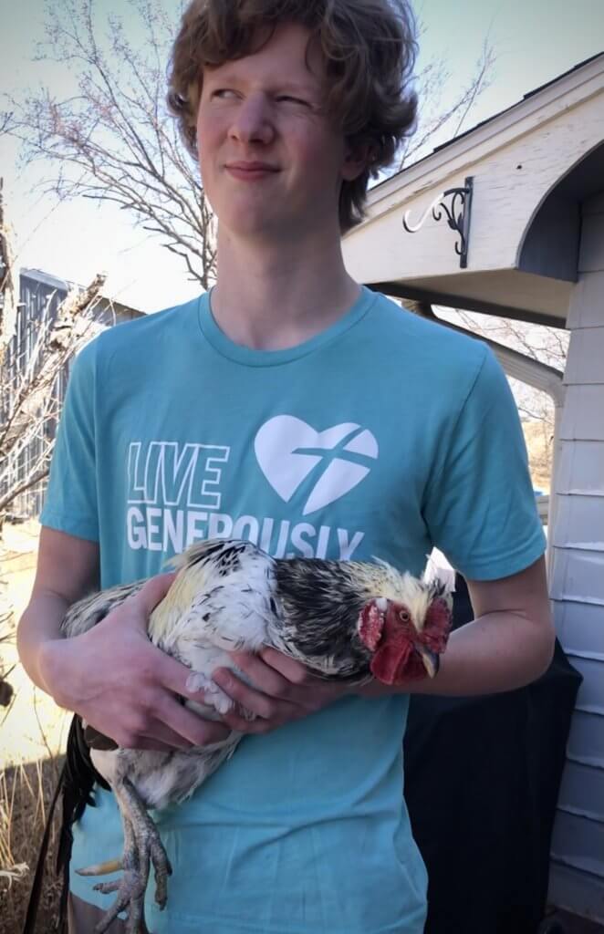young man holding rooster