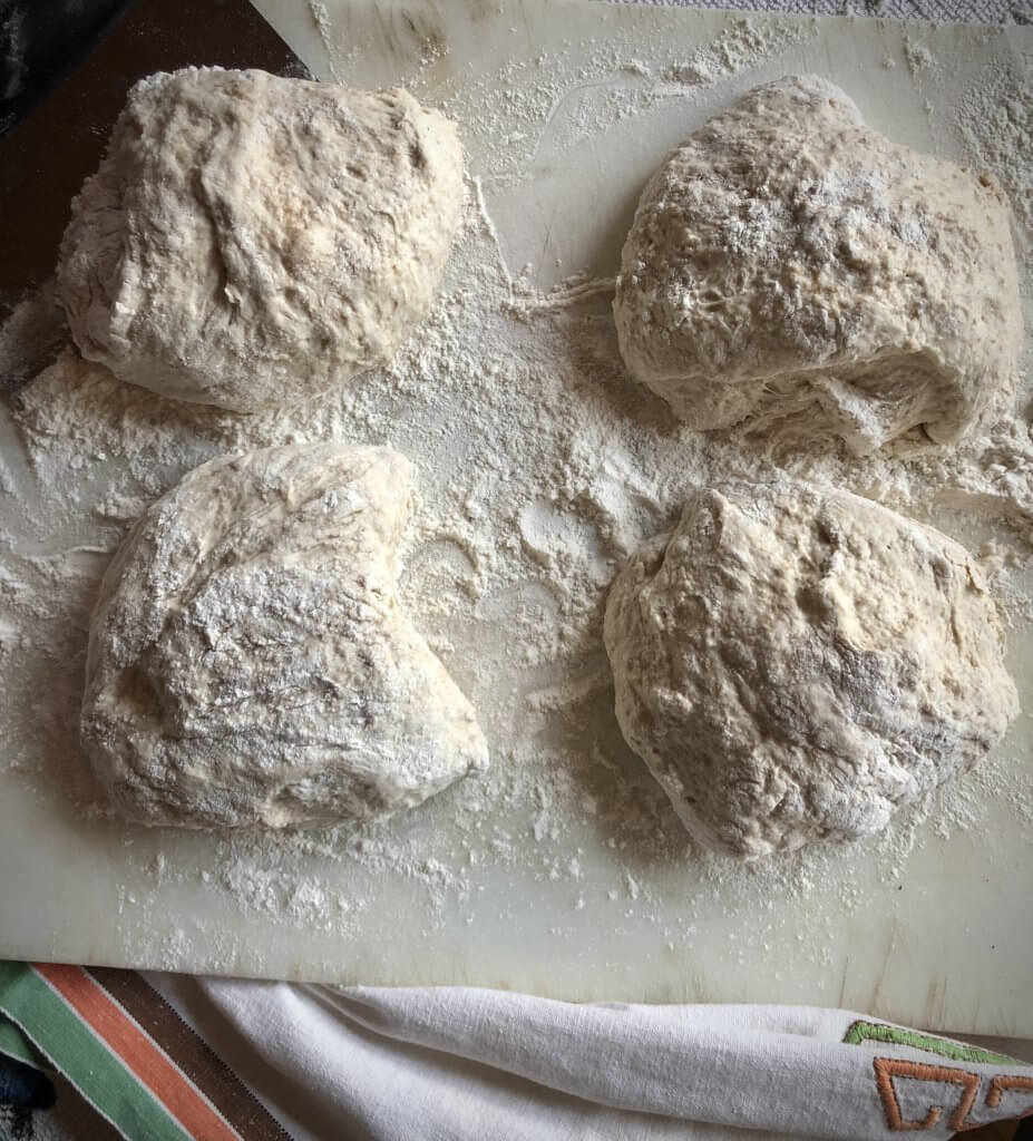 four clumps of dough on white board