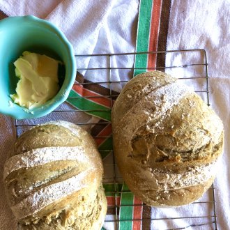 two loaves of bread and a bowl of butter