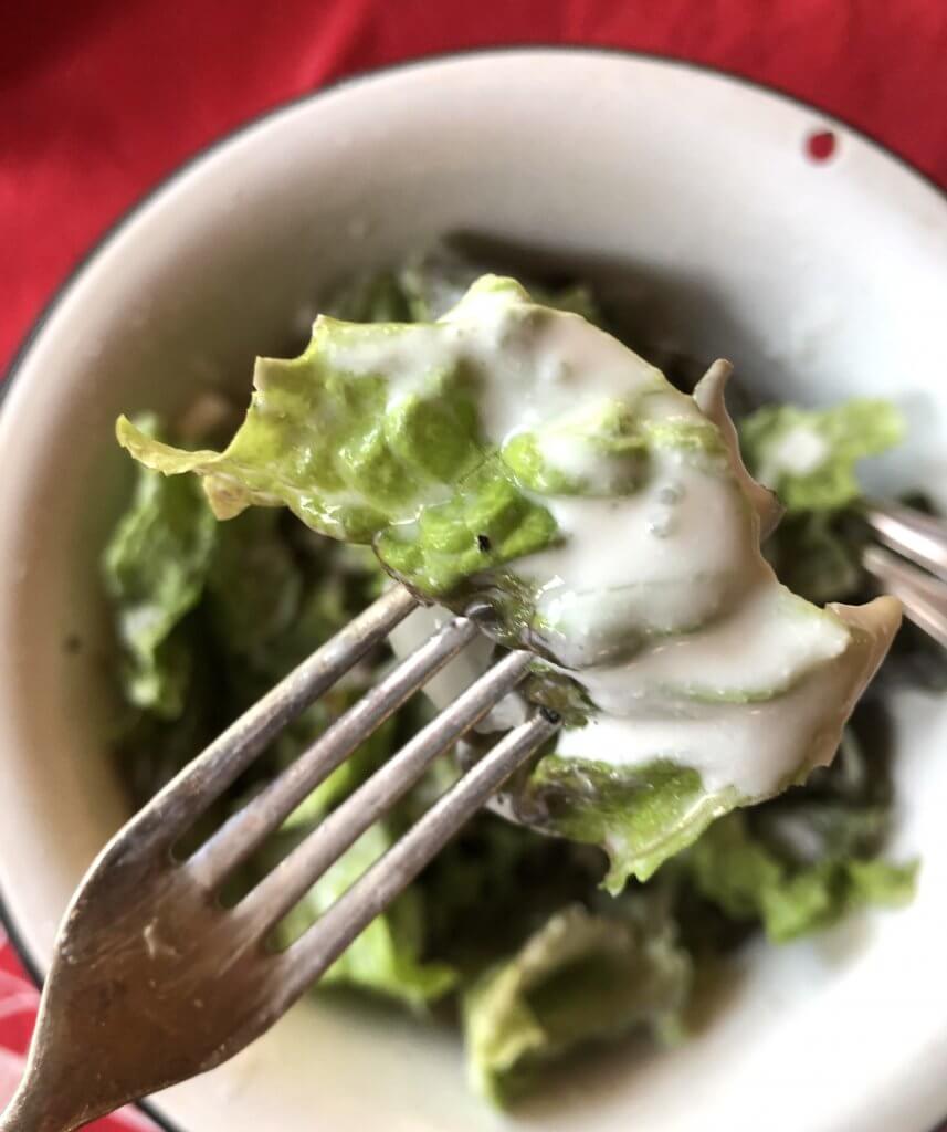 forkful of lettuce salad with creamy dressing