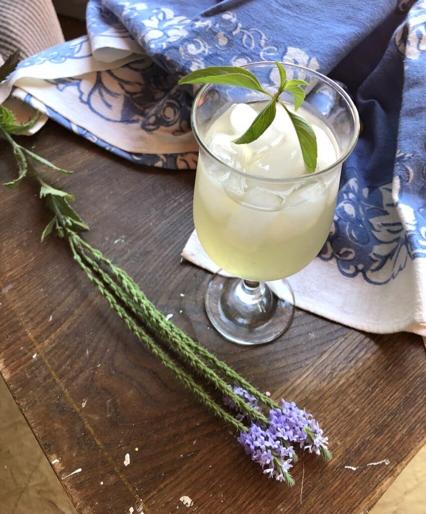 wine glass with pineapple peel tea and herbs