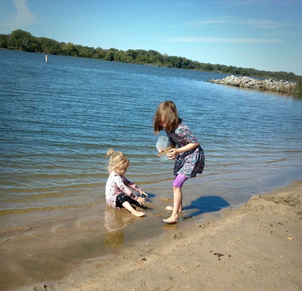 two little girls playing in the lake water