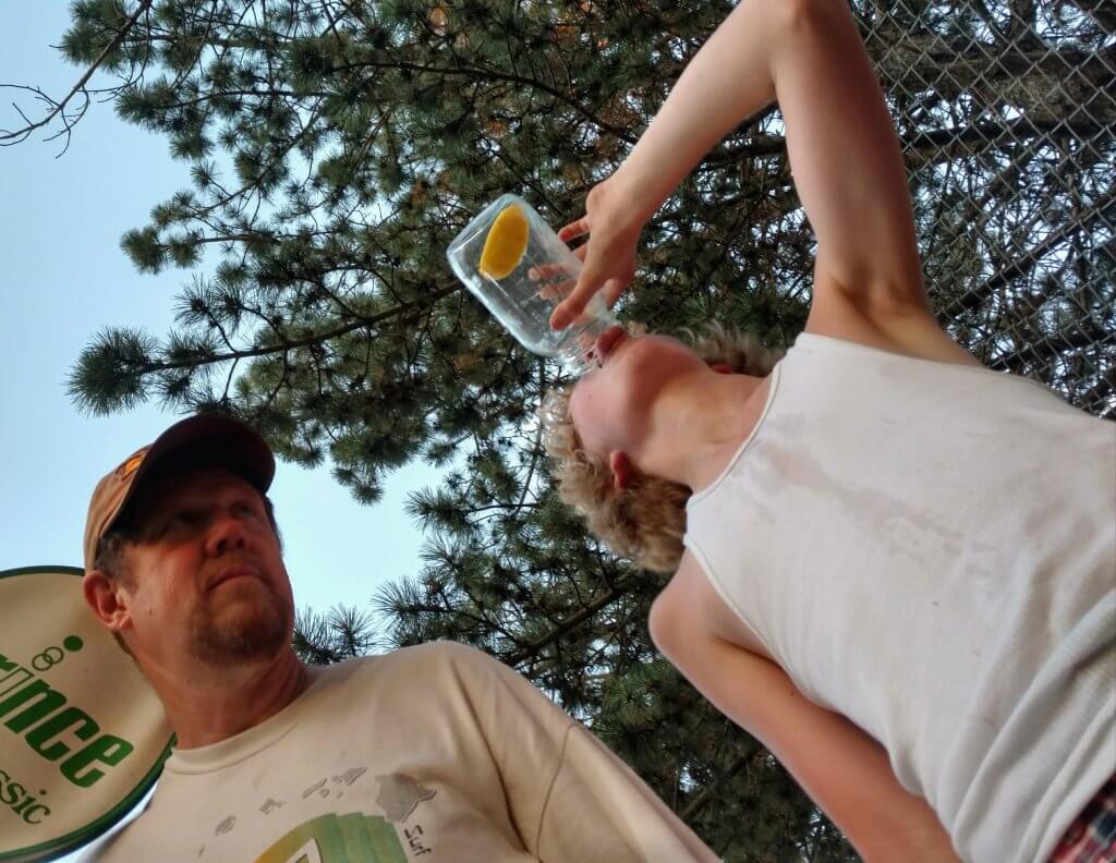 boy drinking from a jar and man