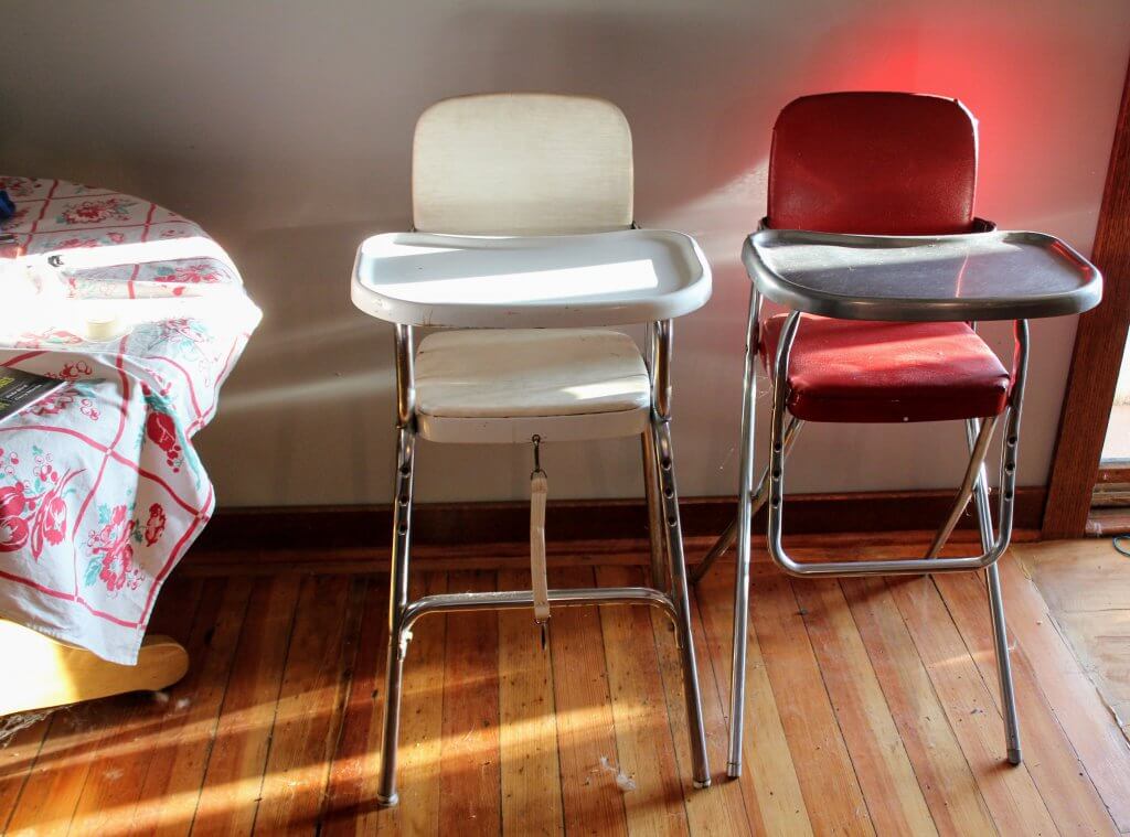 two old high chairs, wooden floor, sunshine