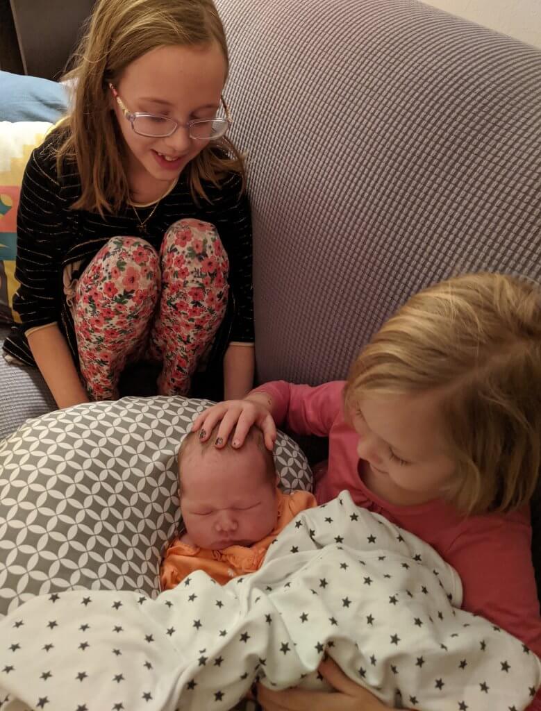 two little girls with new baby