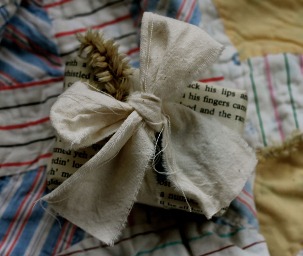 Little bitty package, big bow made of muslin, dried flower and book page.