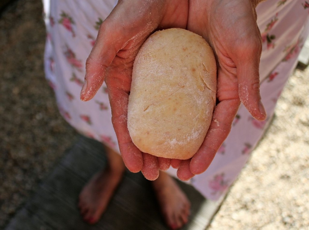 woman's hands holding an unbaked runza